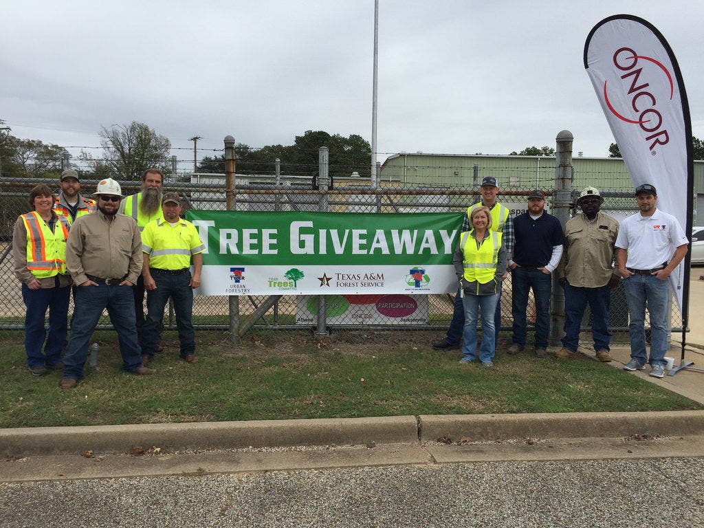 Tree giveaway Oncor employees pose for picture at tree giveaway