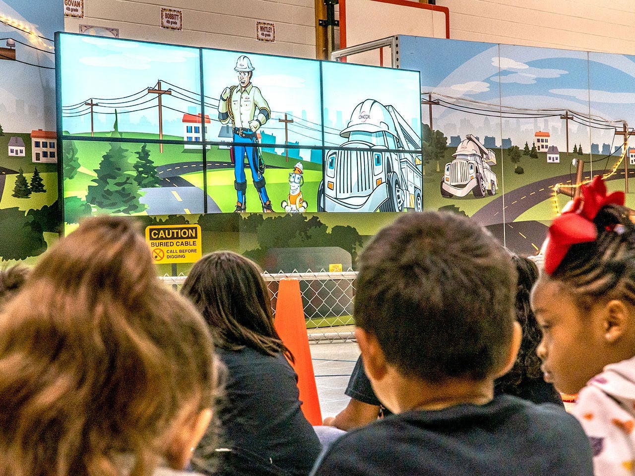 Oncor linemen give students an up-close lesson on electrical safety during a live Touch-A-Truck appearance at their school.